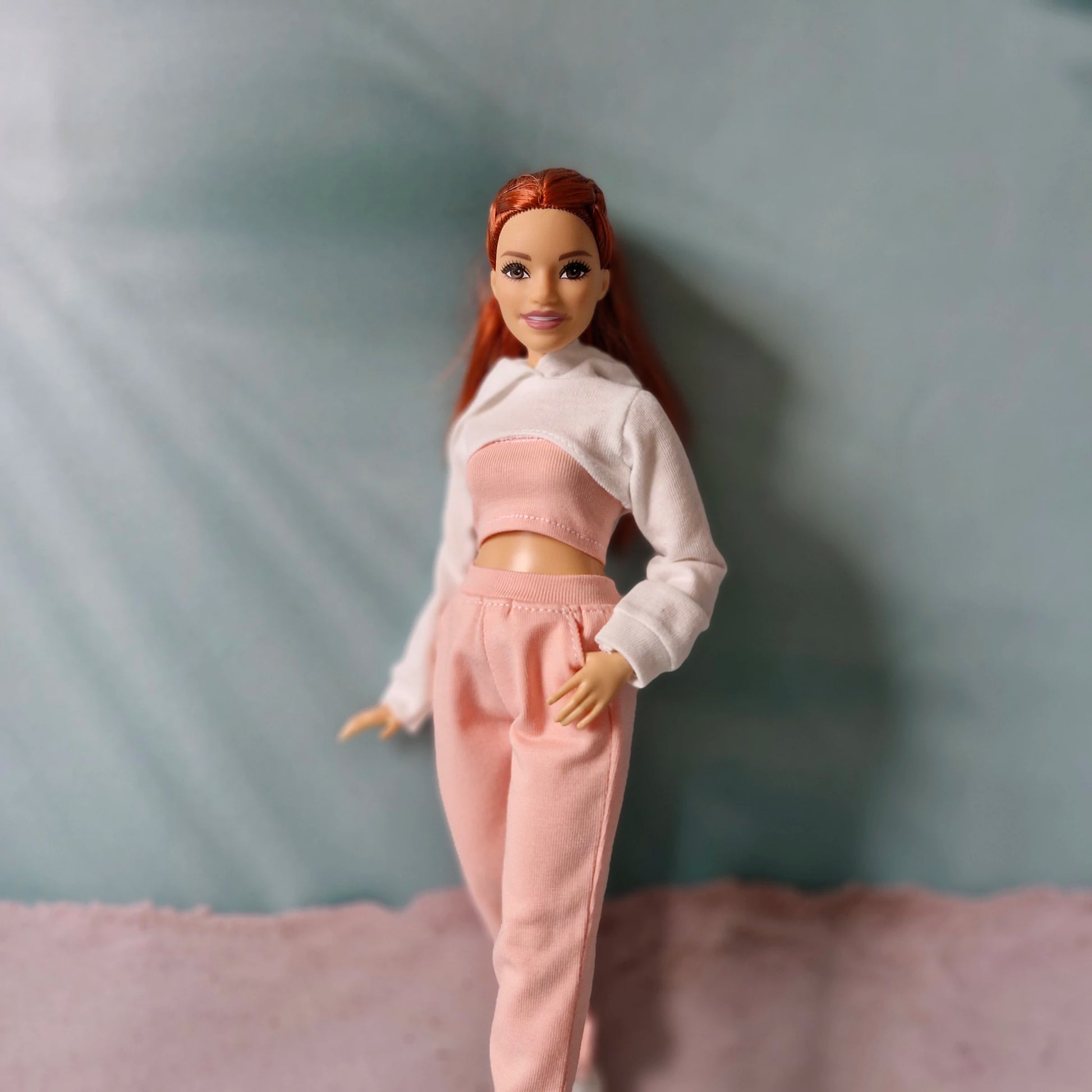Barbie doll wearing a gray oversized jacket layered over a pink tube top and pink sweatpants.
