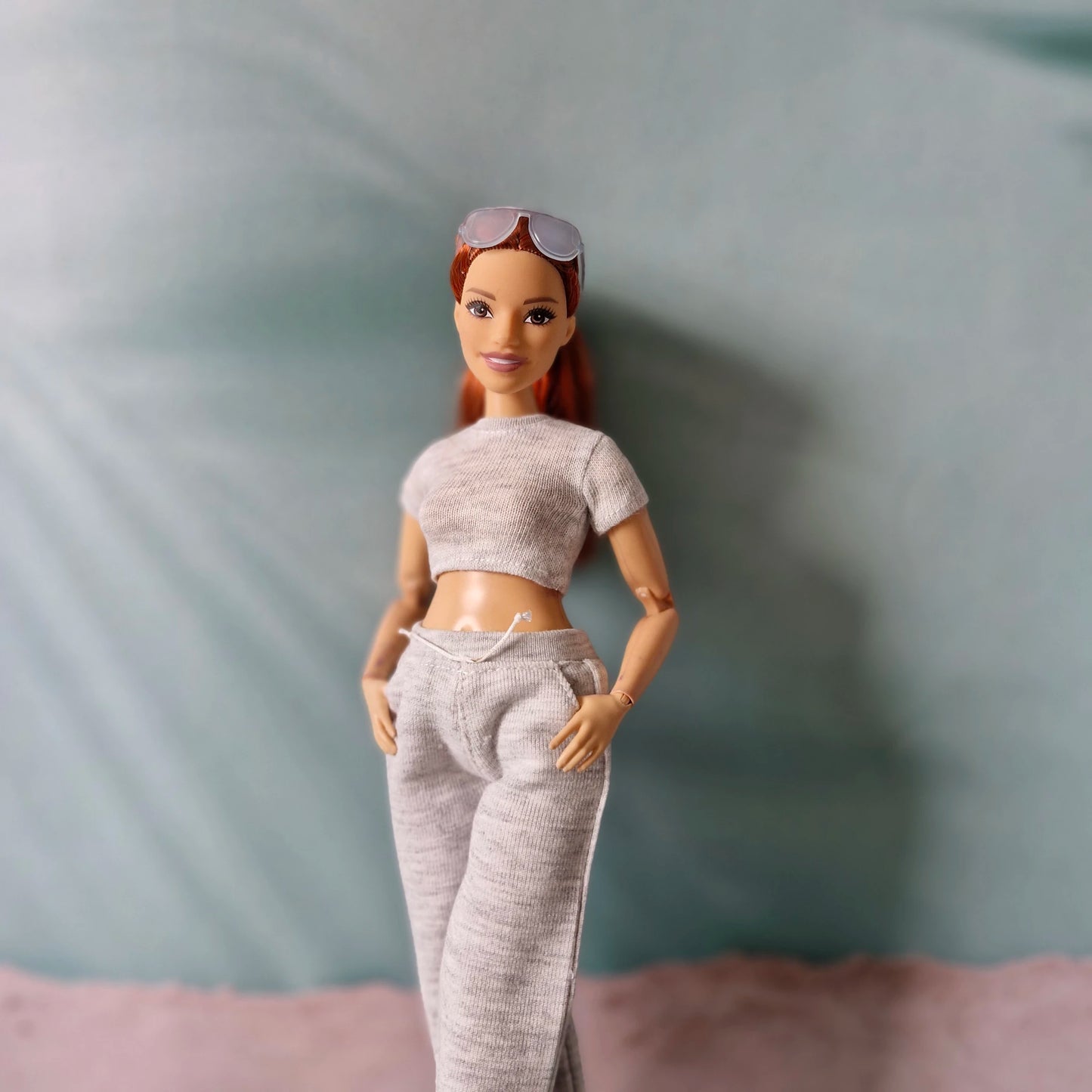 barbie doll wearing grey crop top and sweatpants close up
