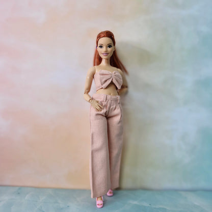 Barbie Curvy doll in blush pink bow crop top and wide-leg trousers, pastel fashion set.
