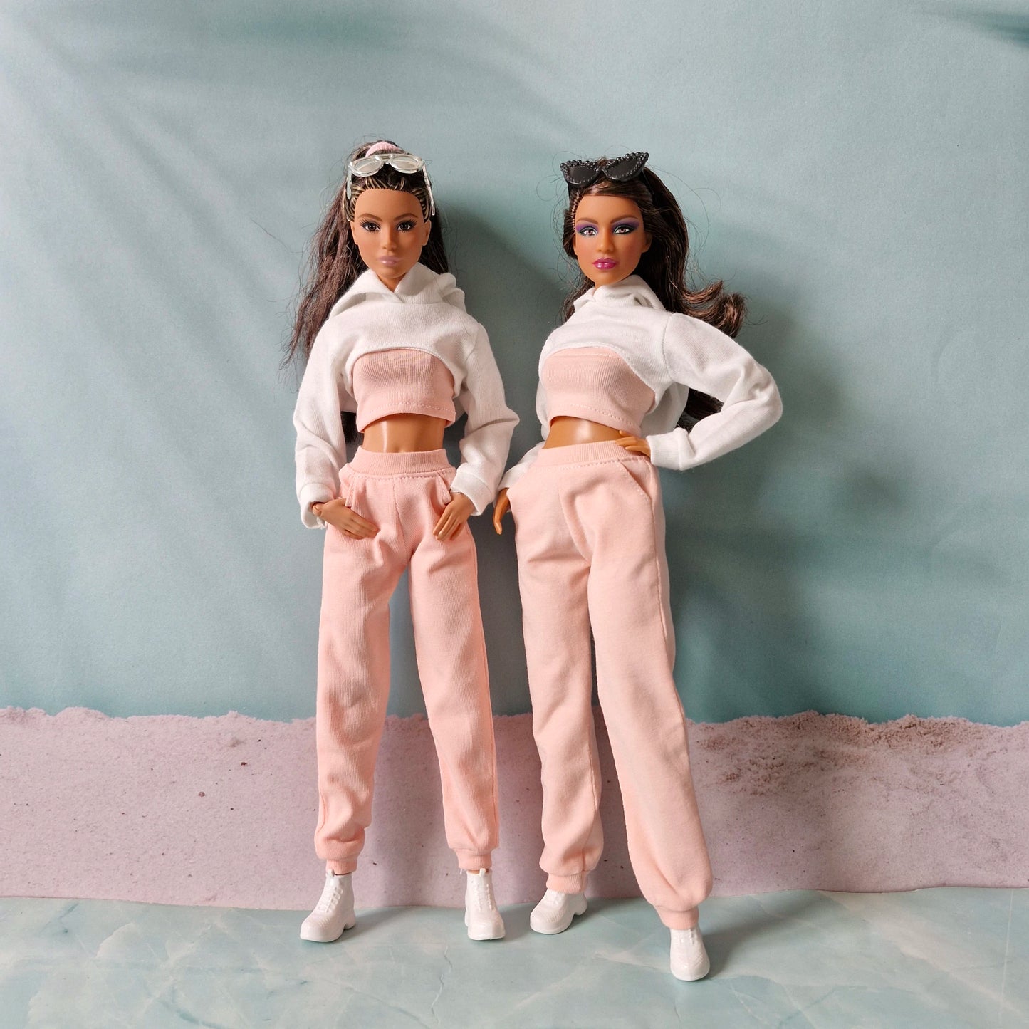 Two Barbie dolls wearing matching pink and white streetwear outfits in curvy and regular sizes