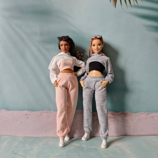 Two fashion dolls posing together wearing pink and grey casual athletic doll clothes