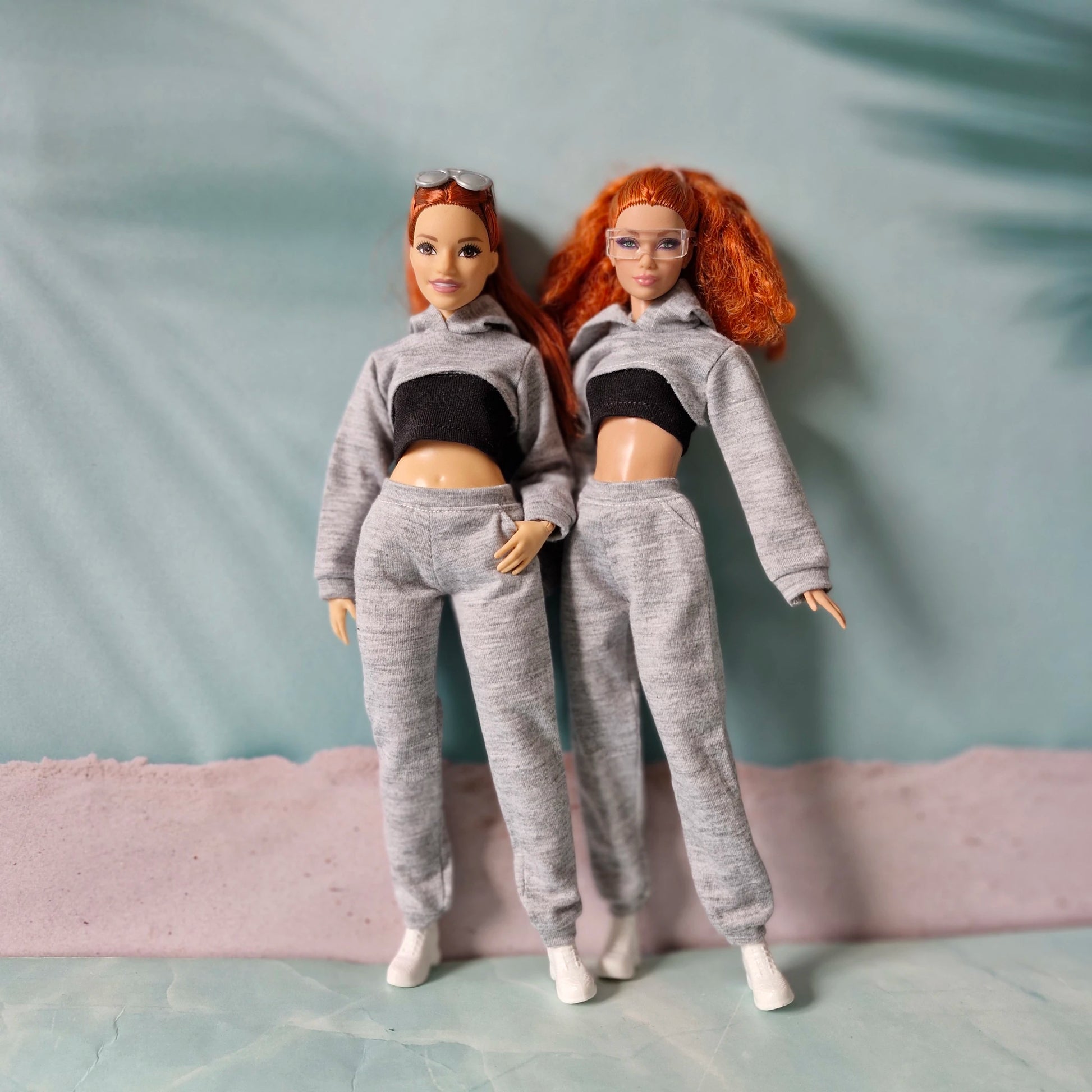 Comparison of curvy and regular size Barbie dolls wearing grey sporty hoodie and jogger sets