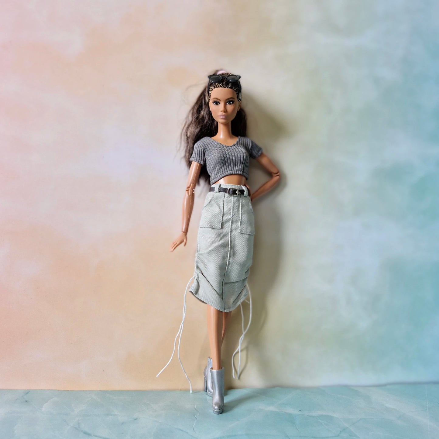 Brunette Barbie doll posing in grey ribbed top and grey midi cargo skirt with drawstrings
