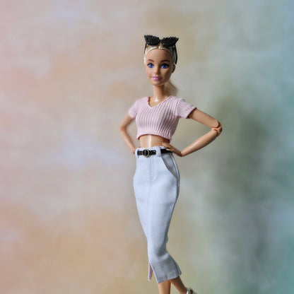 Blonde Barbie doll modeling baby pink crop top and white midi pencil skirt with front slit