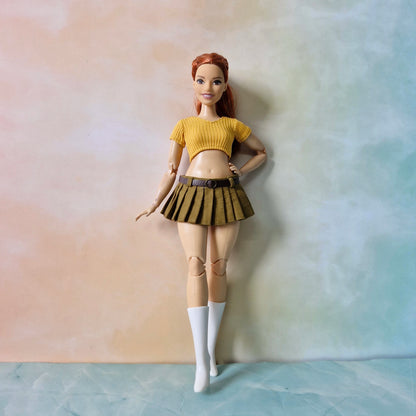 Curvy Barbie style doll standing wearing yellow monochromatic skirt and top set