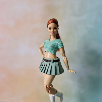 Curvy doll modeling mint green aesthetic outfit with pleated skirt and crop top