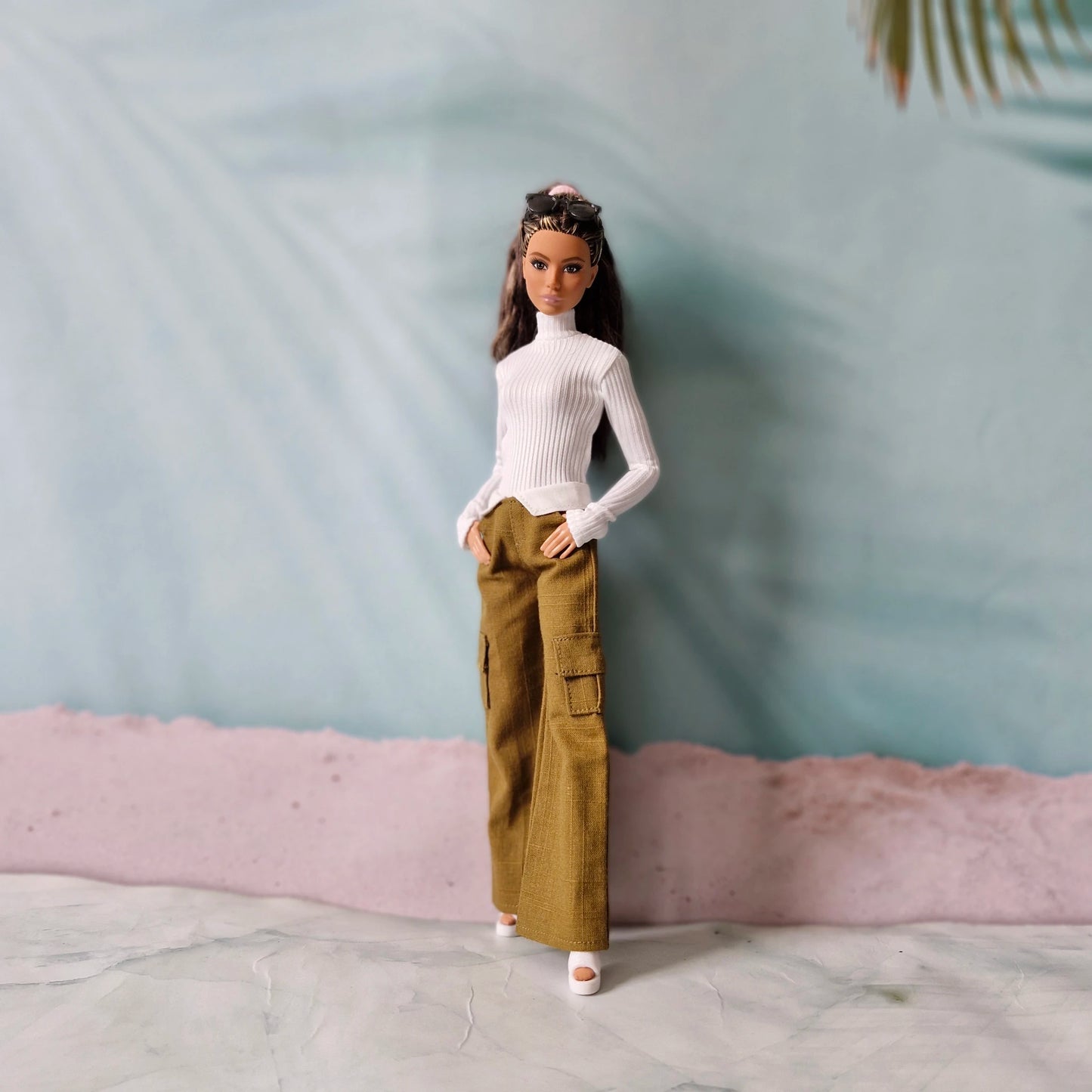 Brunette Barbie doll wearing white turtleneck top and olive brown cargo pants