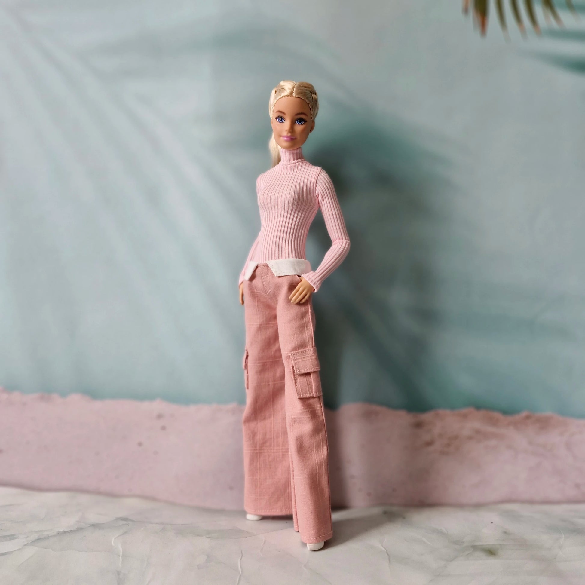 Blonde Barbie doll wearing pink turtleneck top and pink wide leg cargo pants