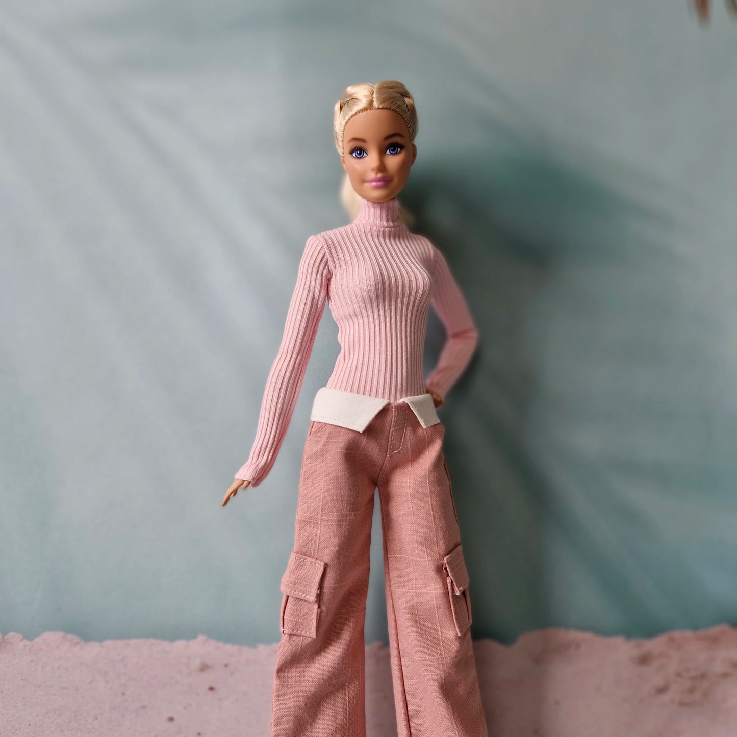 Blonde fashion doll modeling monochromatic pink cargo trousers and turtleneck sweater