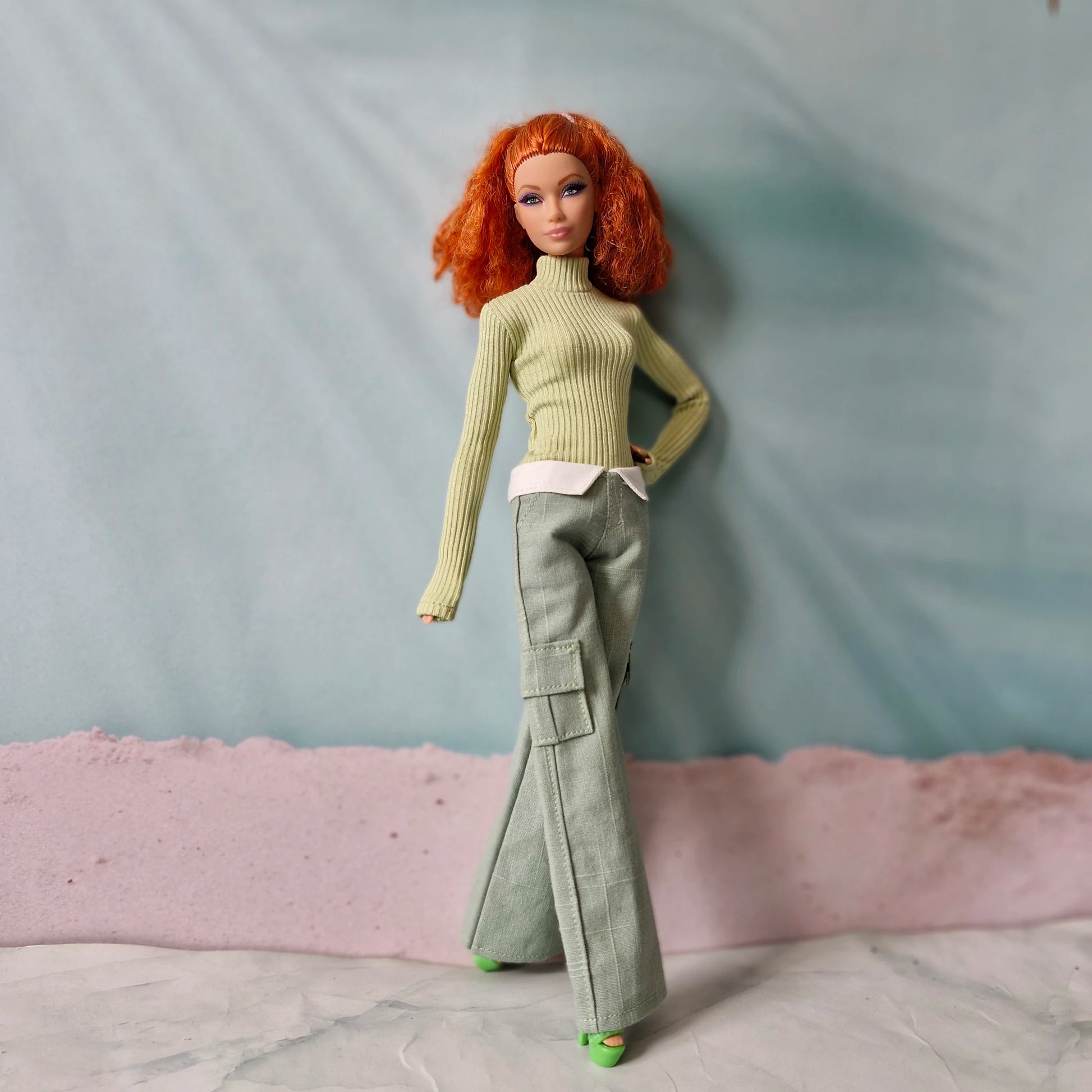 Fashion doll posing in green ribbed long sleeve top and wide leg trousers