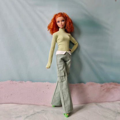 Fashion doll posing in green ribbed long sleeve top and wide leg trousers