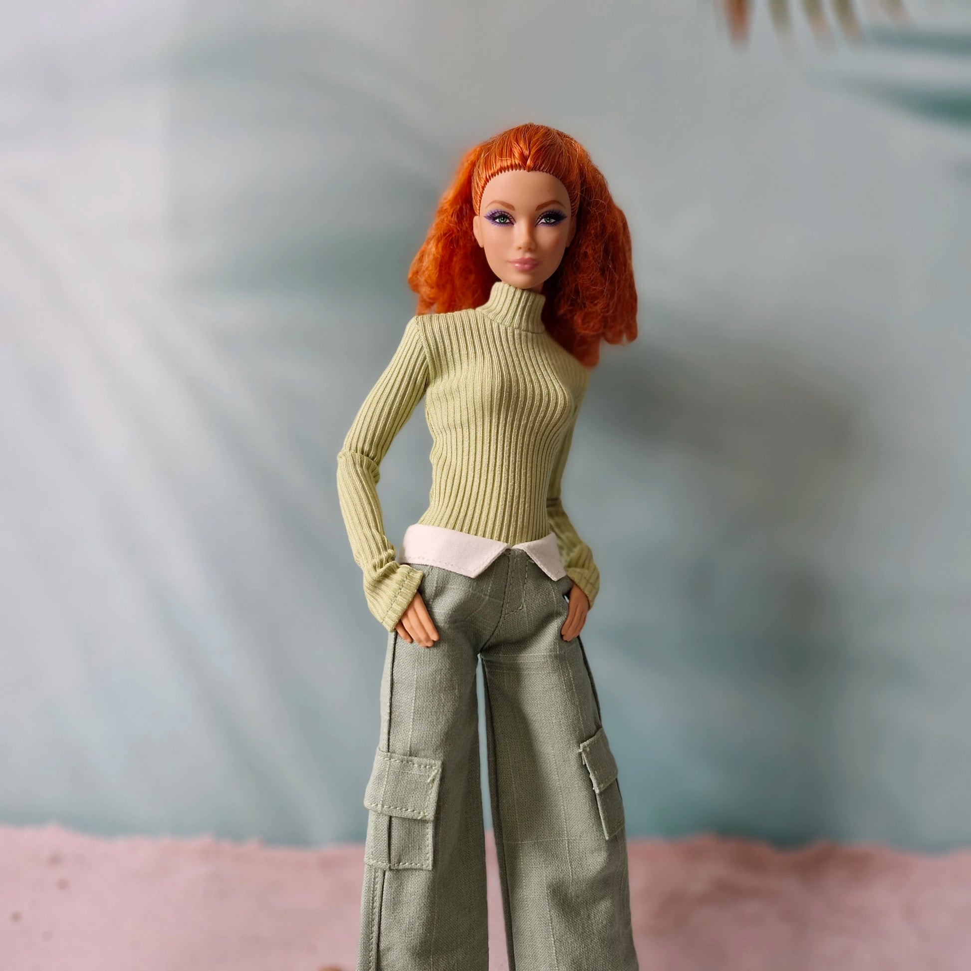 Redhead doll wearing sage green turtleneck sweater and grey-green cargo pants