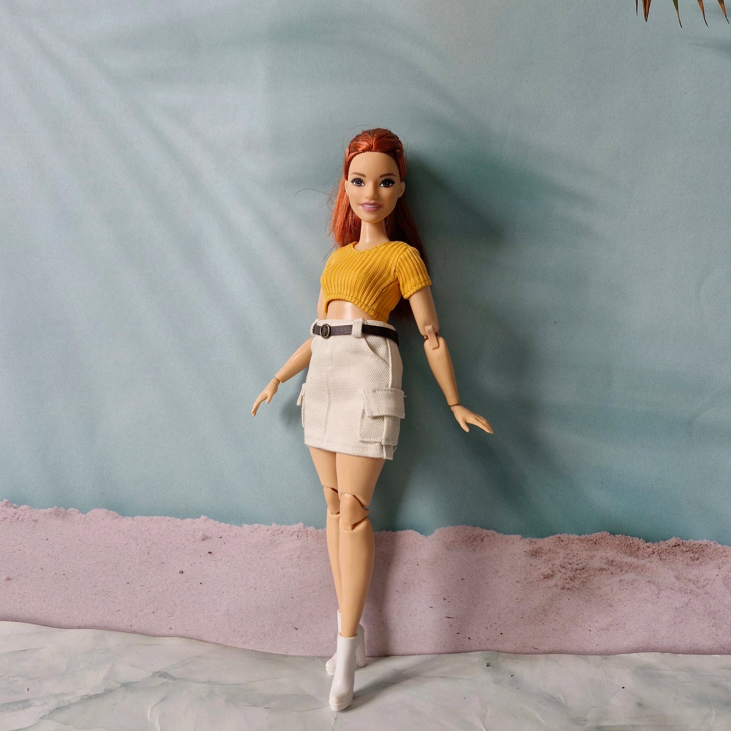 Full body shot of redhead curvy doll in casual streetwear separates yellow top and white skirt