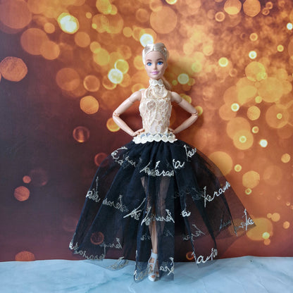 Barbie doll posing in a luxurious gold halter lace top and high-low black tulle skirt