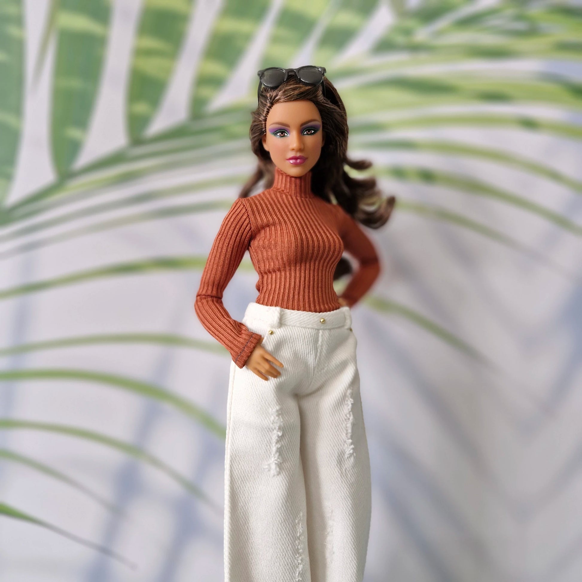 Curvy Barbie modeling a rust orange long sleeve top and white distressed wide-leg jeans