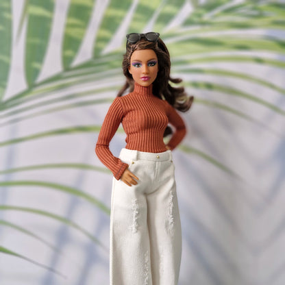 Curvy Barbie modeling a rust orange long sleeve top and white distressed wide-leg jeans