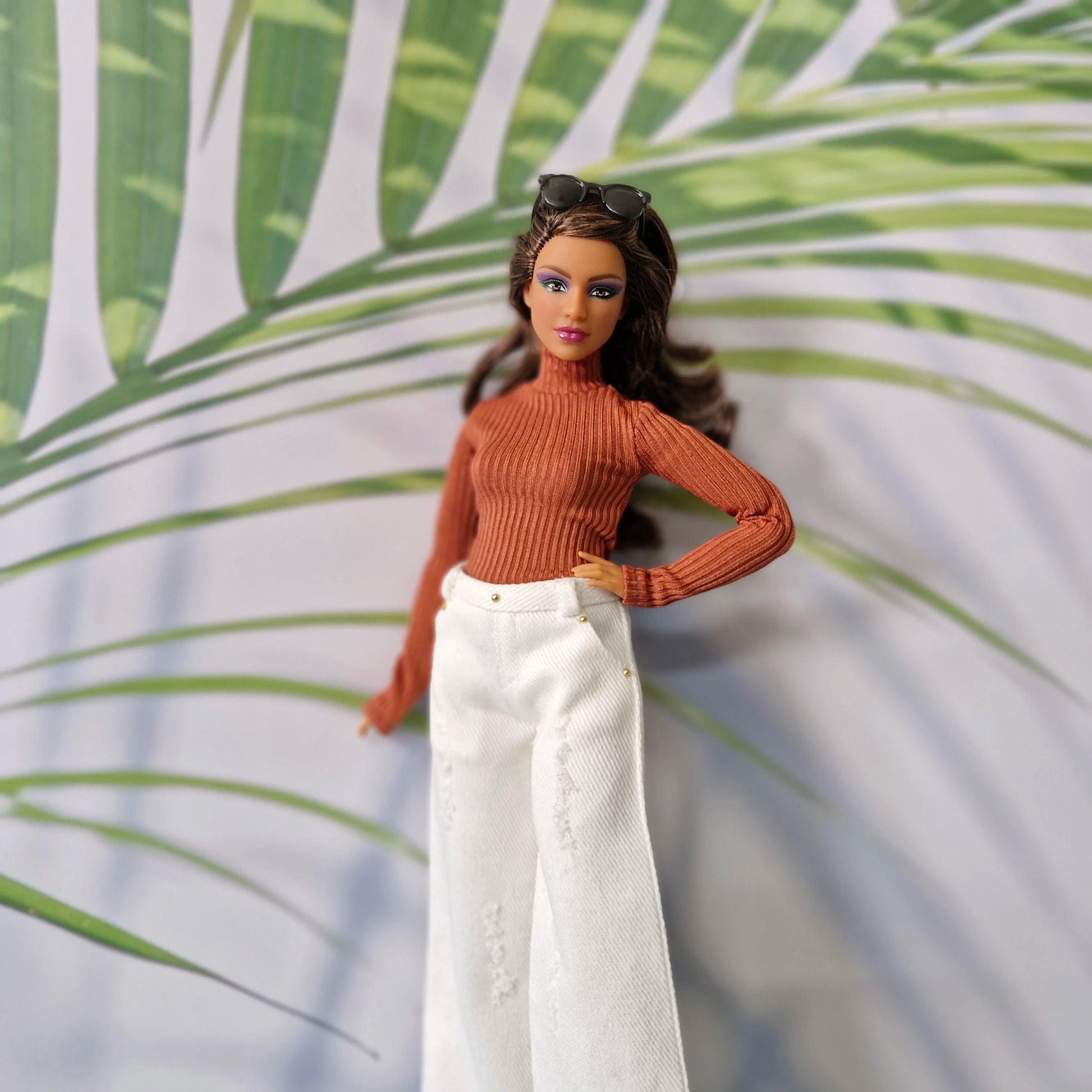 Curvy Barbie modeling a rust orange long sleeve top and white distressed wide-leg jeans