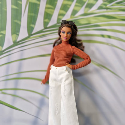 Curvy Barbie modeling a rust orange long sleeve top and white distressed wide-leg jeans