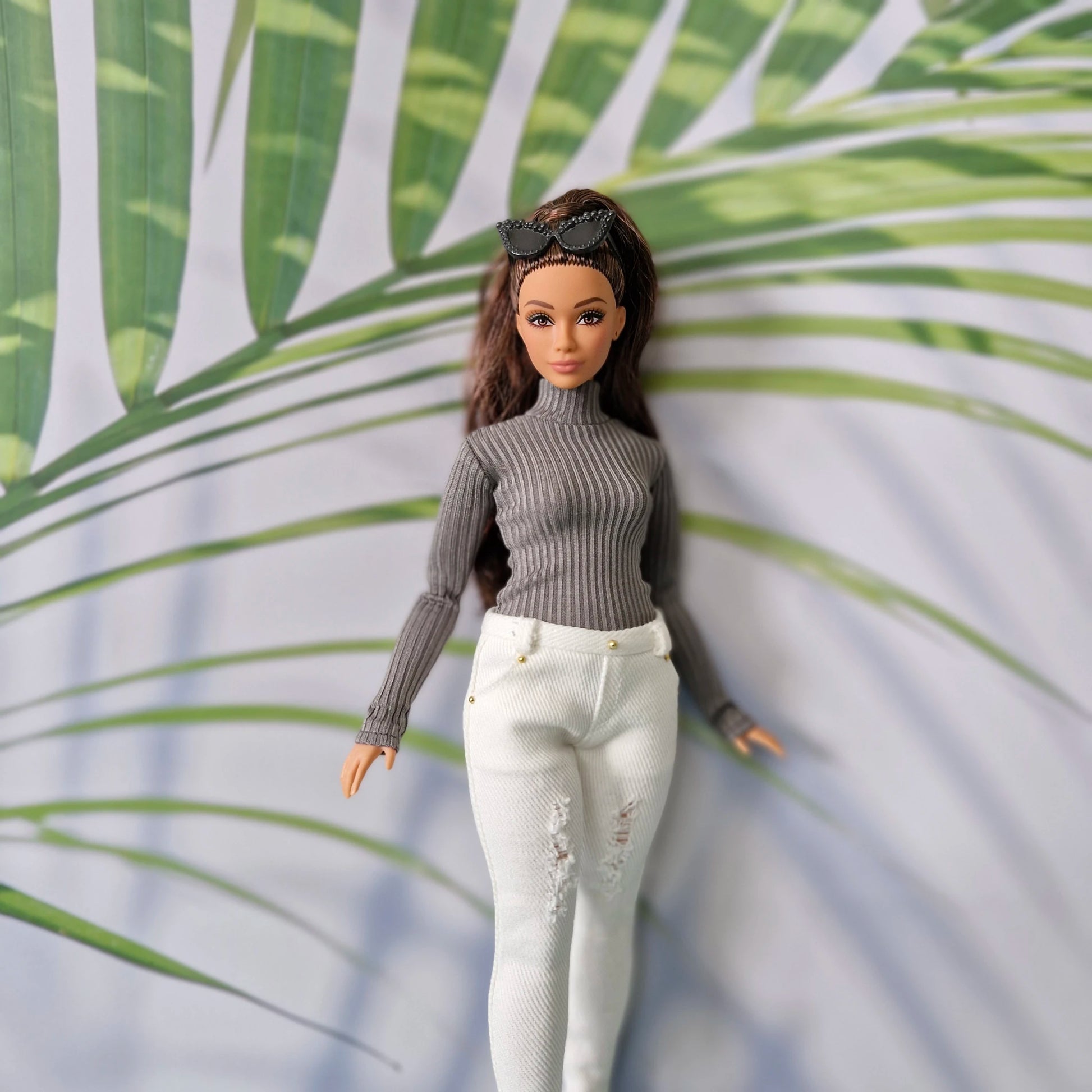 Brunette Curvy Barbie wearing a dark grey turtleneck sweater and white distressed skinny jeans