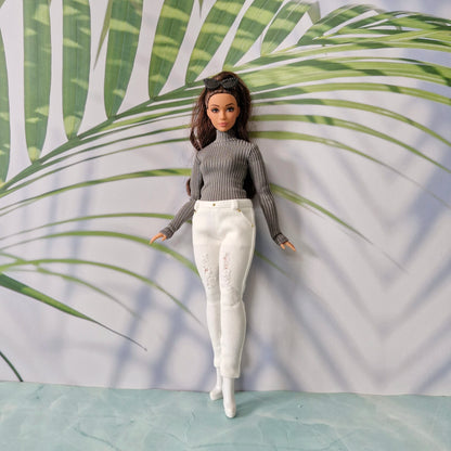 Brunette Curvy Barbie wearing a dark grey turtleneck sweater and white distressed skinny jeans