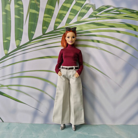 Curvy Barbie doll wearing a burgundy ribbed turtleneck sweater and wide-leg pants