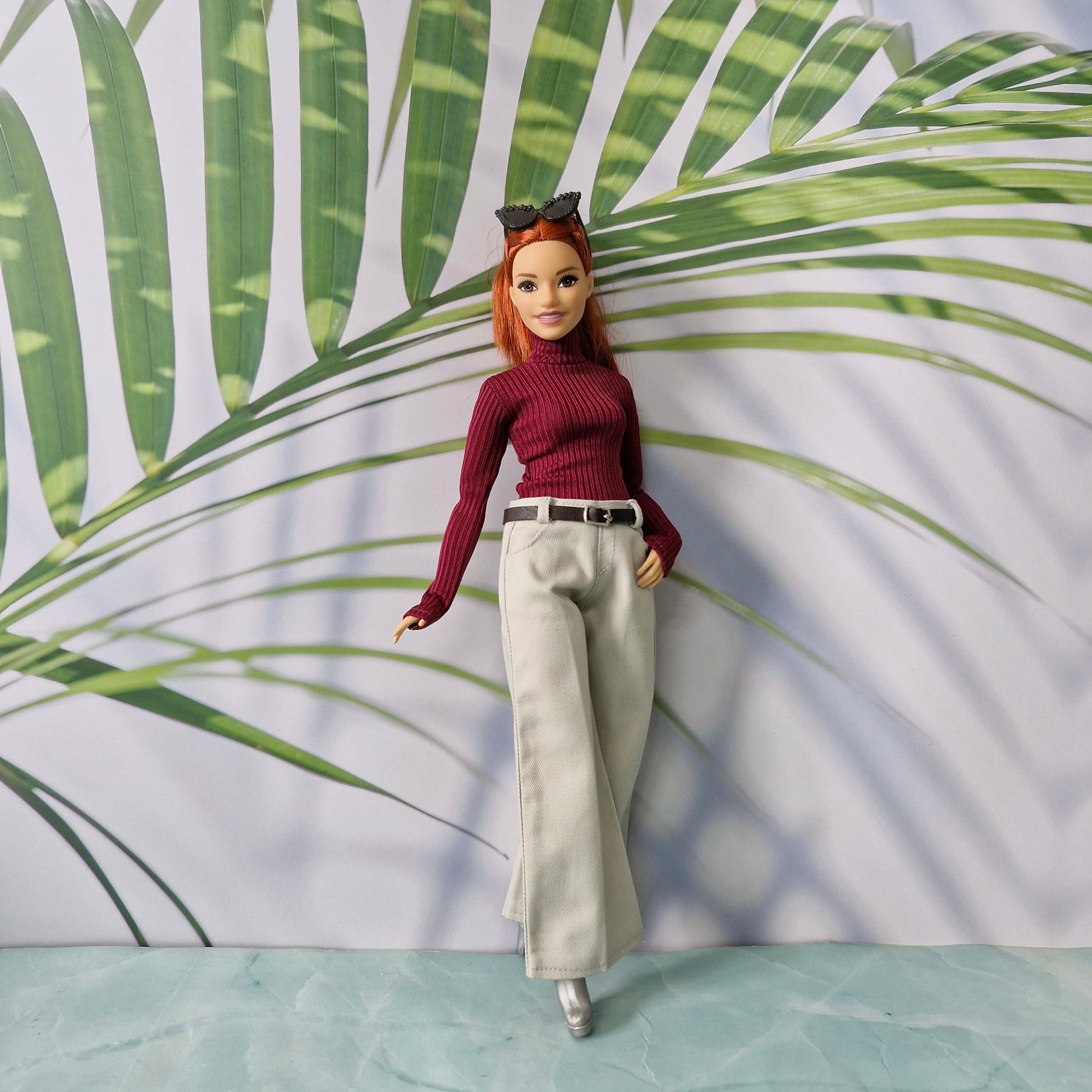 Curvy Barbie doll wearing a burgundy ribbed turtleneck sweater and wide-leg pants