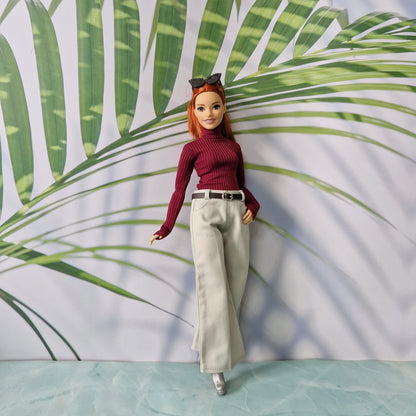 Curvy Barbie doll wearing a burgundy ribbed turtleneck sweater and wide-leg pants