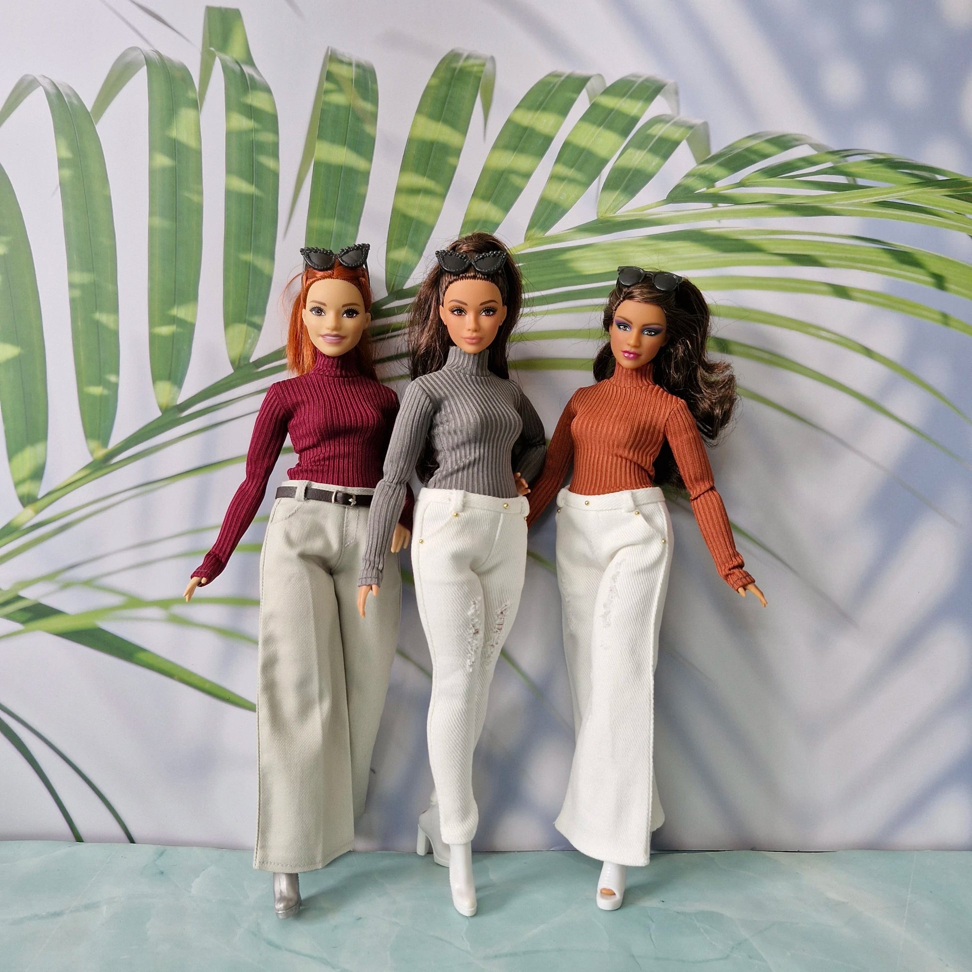 Group of three Curvy Barbie dolls modeling mix and match turtlenecks and pants in beige and white denim