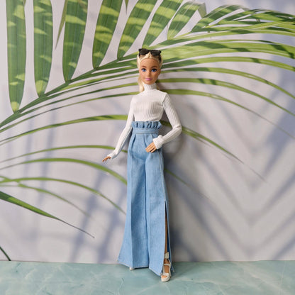 Full body shot of fashion doll in light blue slit denim trousers and white sweater