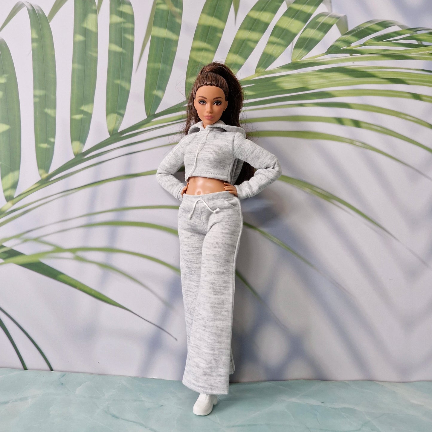 Full length view of Barbie doll dressed in grey cropped hoodie and wide leg pants