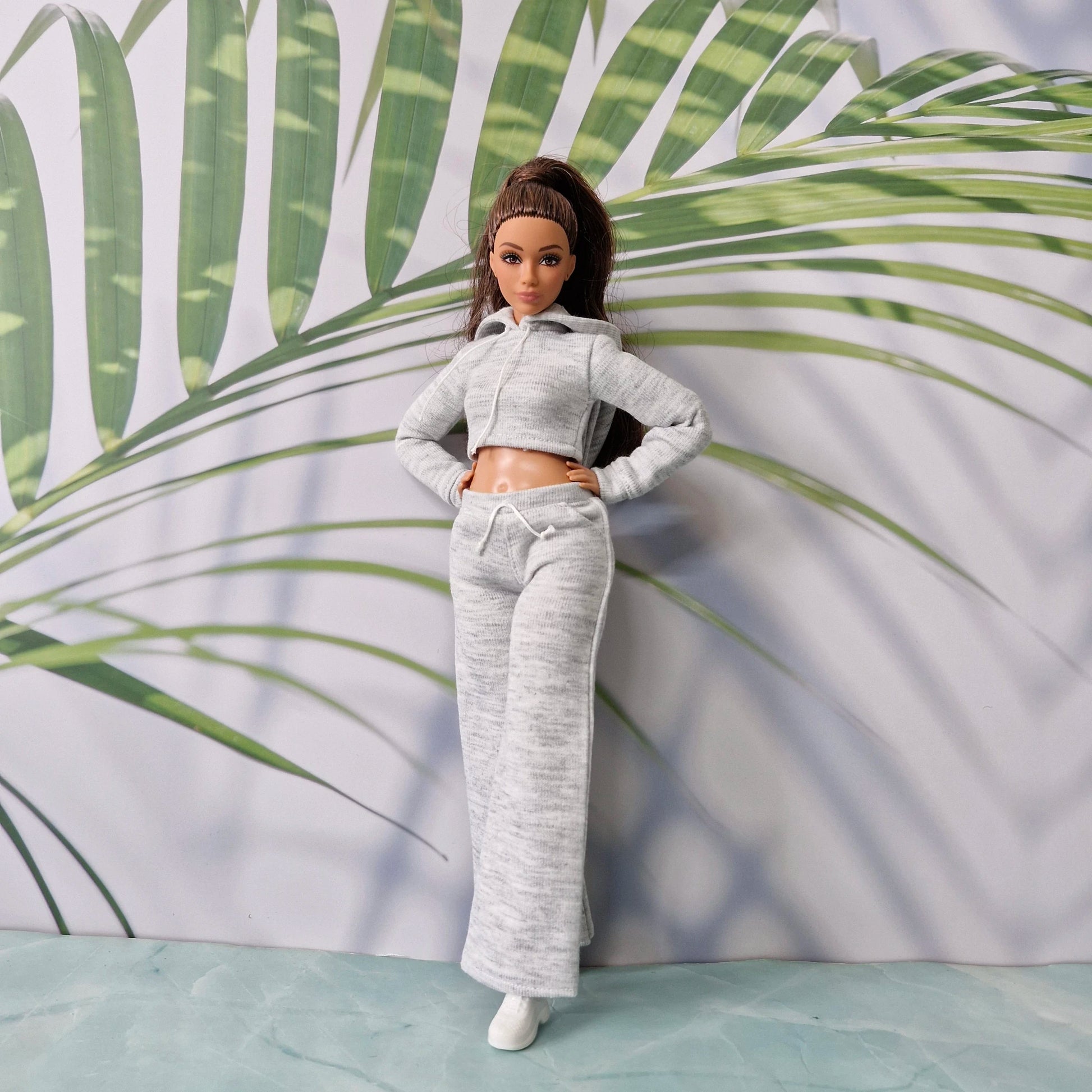 Full length view of Barbie doll dressed in grey cropped hoodie and wide leg pants