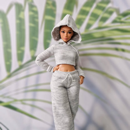 Barbie doll with hood up wearing a grey athletic hoodie and sweatpants