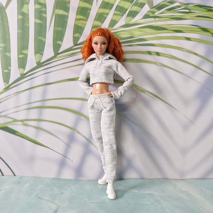 Redhead Barbie doll standing in grey athletic hoodie and jogger pants