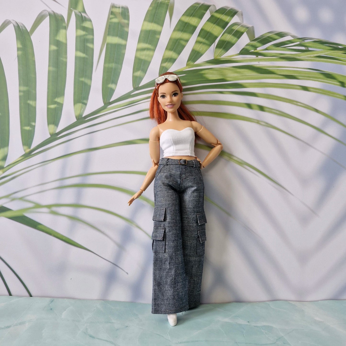 Redhead Barbie doll in a white tube top and dark denim wide-leg cargo pants