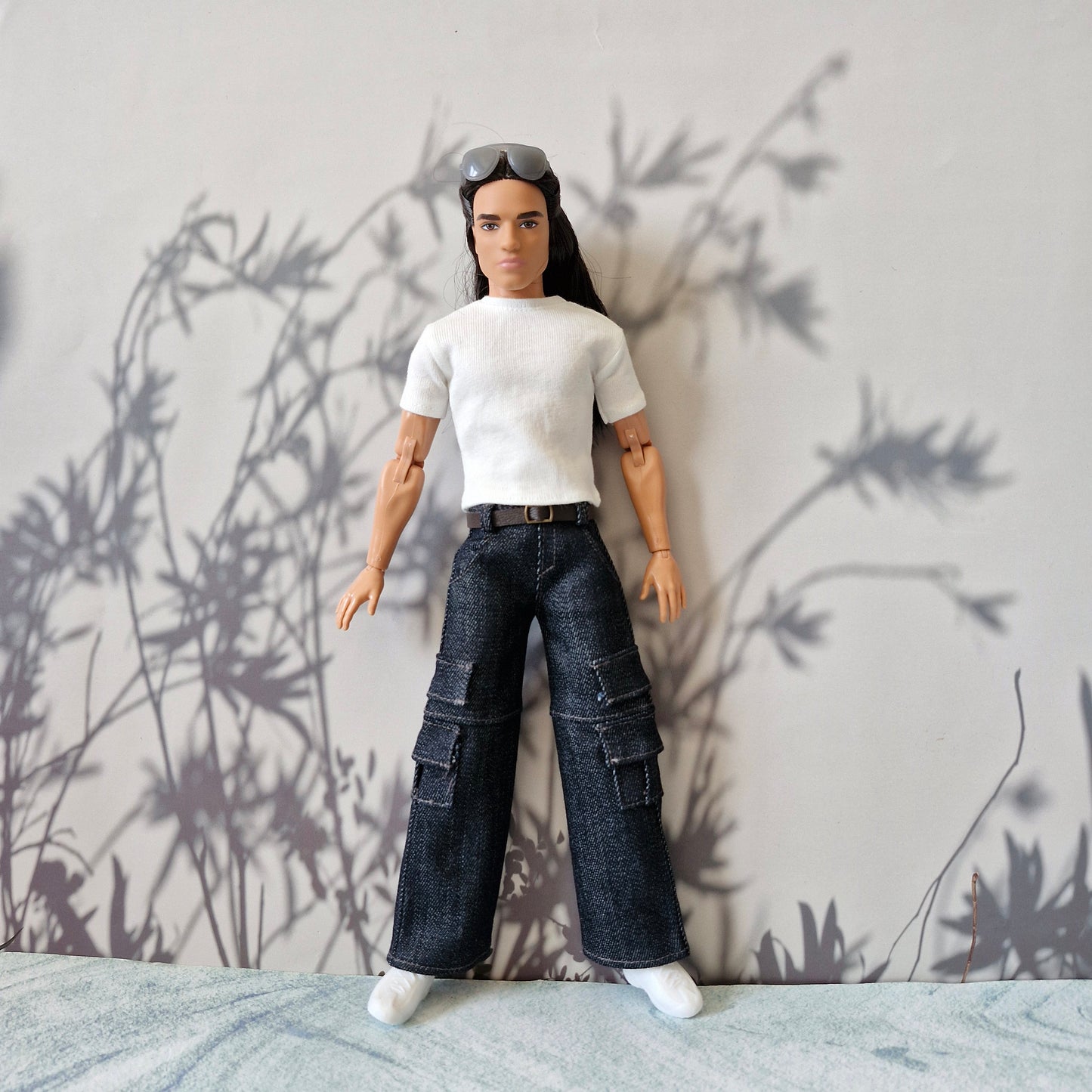 Full body shot of a Ken doll dressed in casual streetwear white shirt and dark denim