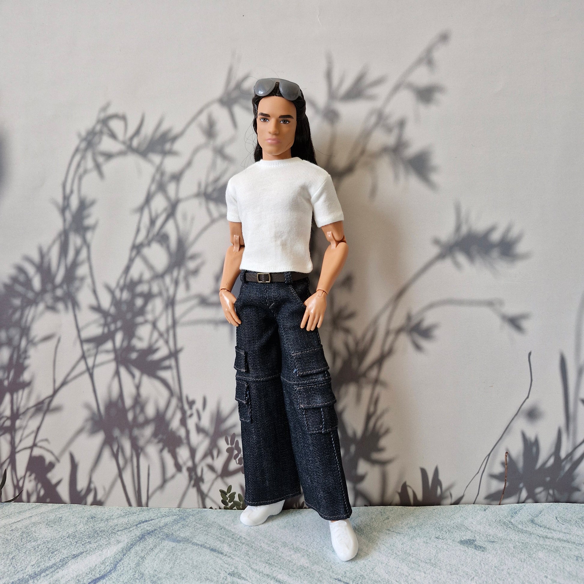 Ken doll looking stylish in a basic white t-shirt and trendy dark cargo pants