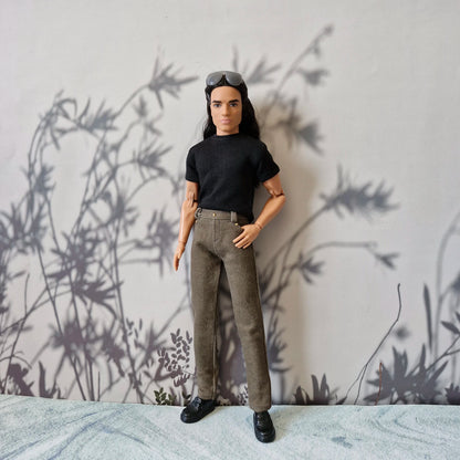 Ken doll modeling a classic black short sleeve t-shirt and tailored brown trousers