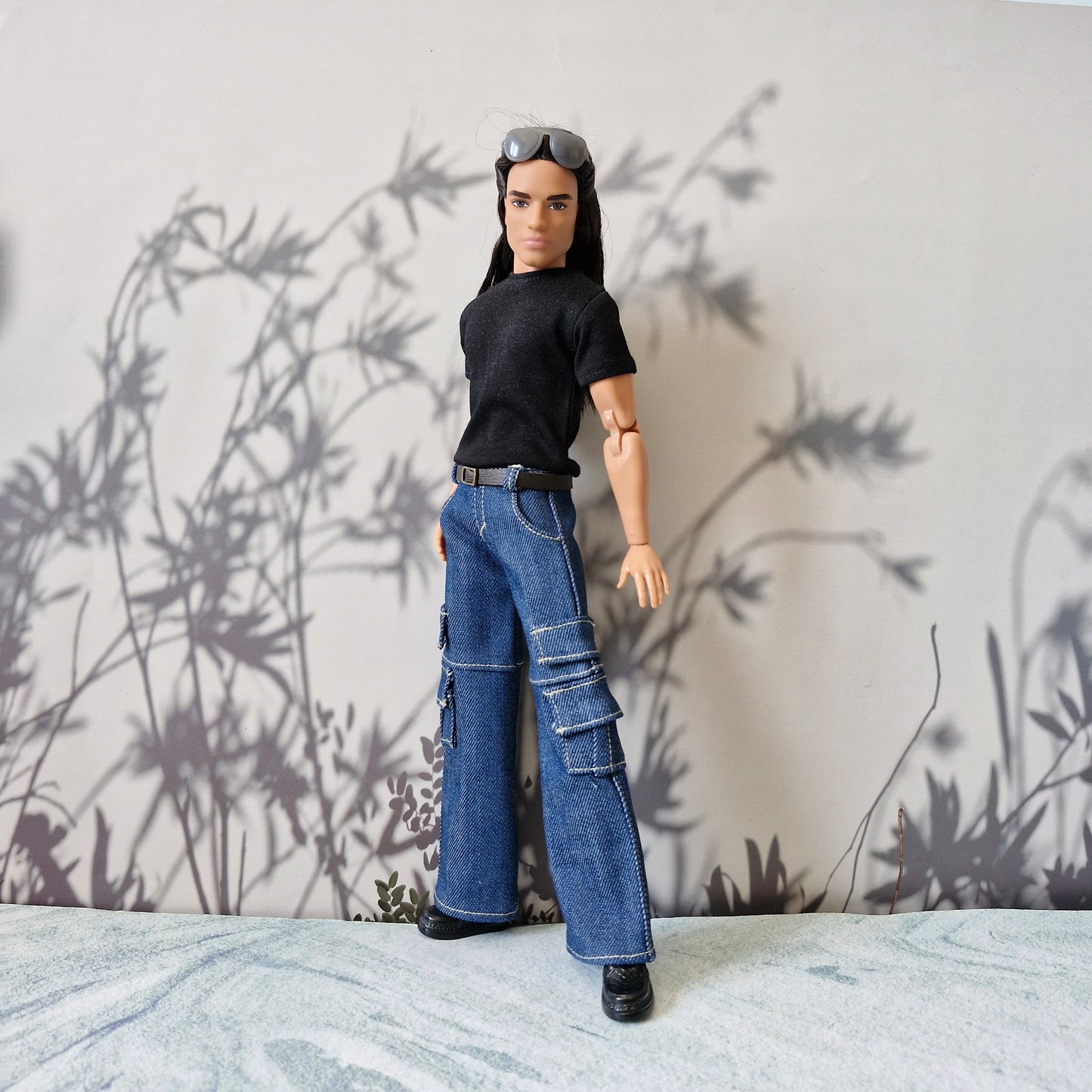 Ken doll wearing a casual black short-sleeve t-shirt and wide-leg blue denim cargo jeans