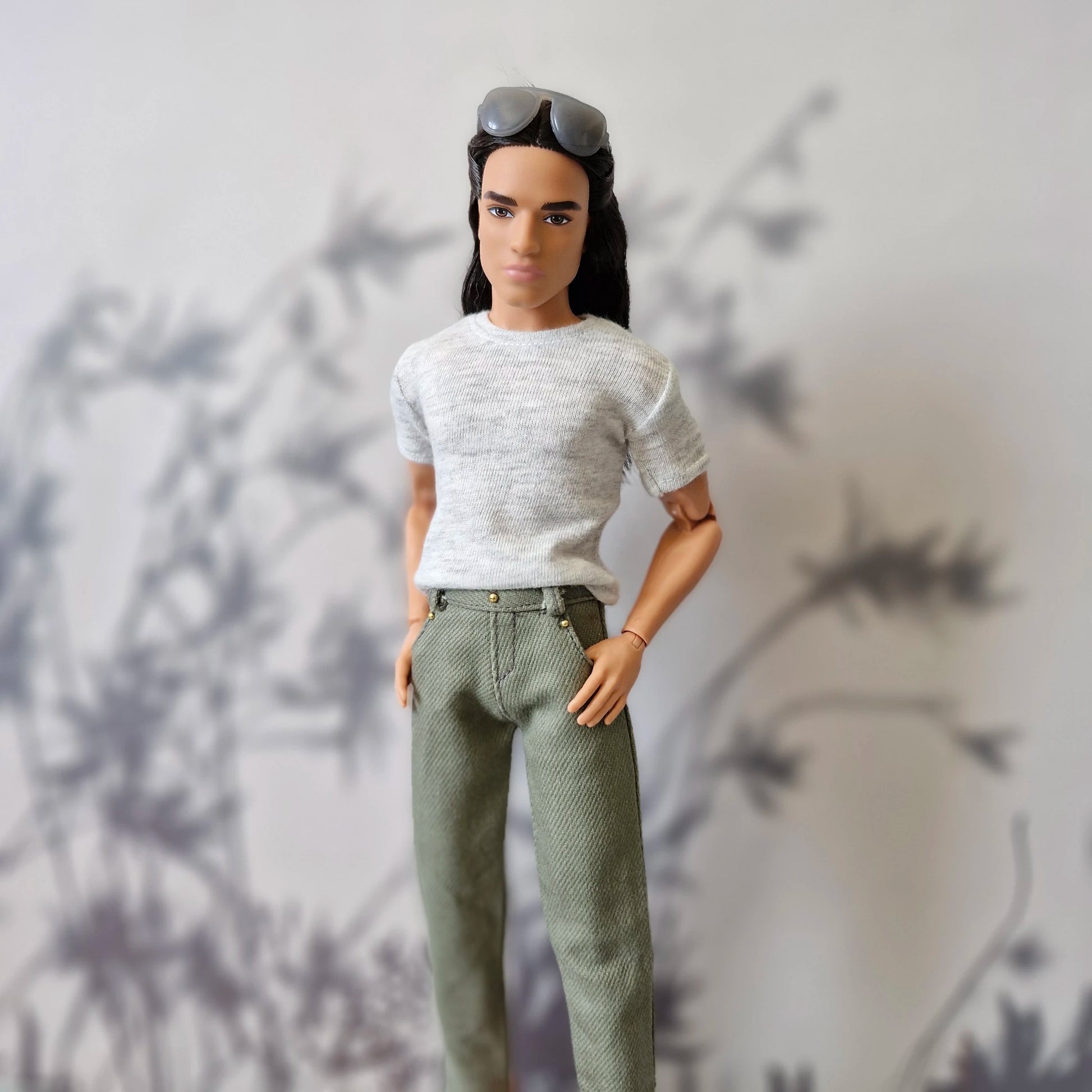 Close up portrait of Ken doll dressed in a casual grey tee and stylish olive green pants