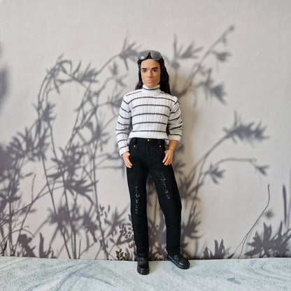 Ken doll wearing a black and white striped long sleeve turtleneck and black distressed jeans