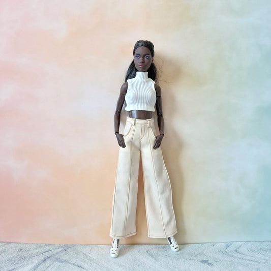 Black Barbie doll modeling a white ribbed sleeveless turtleneck and cream white wide-leg pants