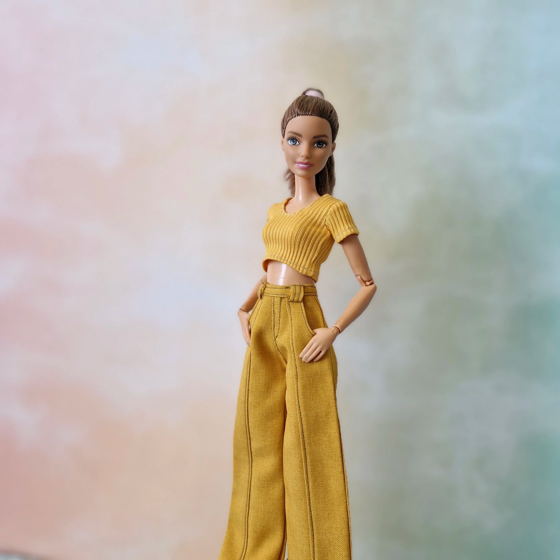 Brunette Barbie doll modeling a mustard yellow short-sleeve ribbed top and matching wide-leg trousers