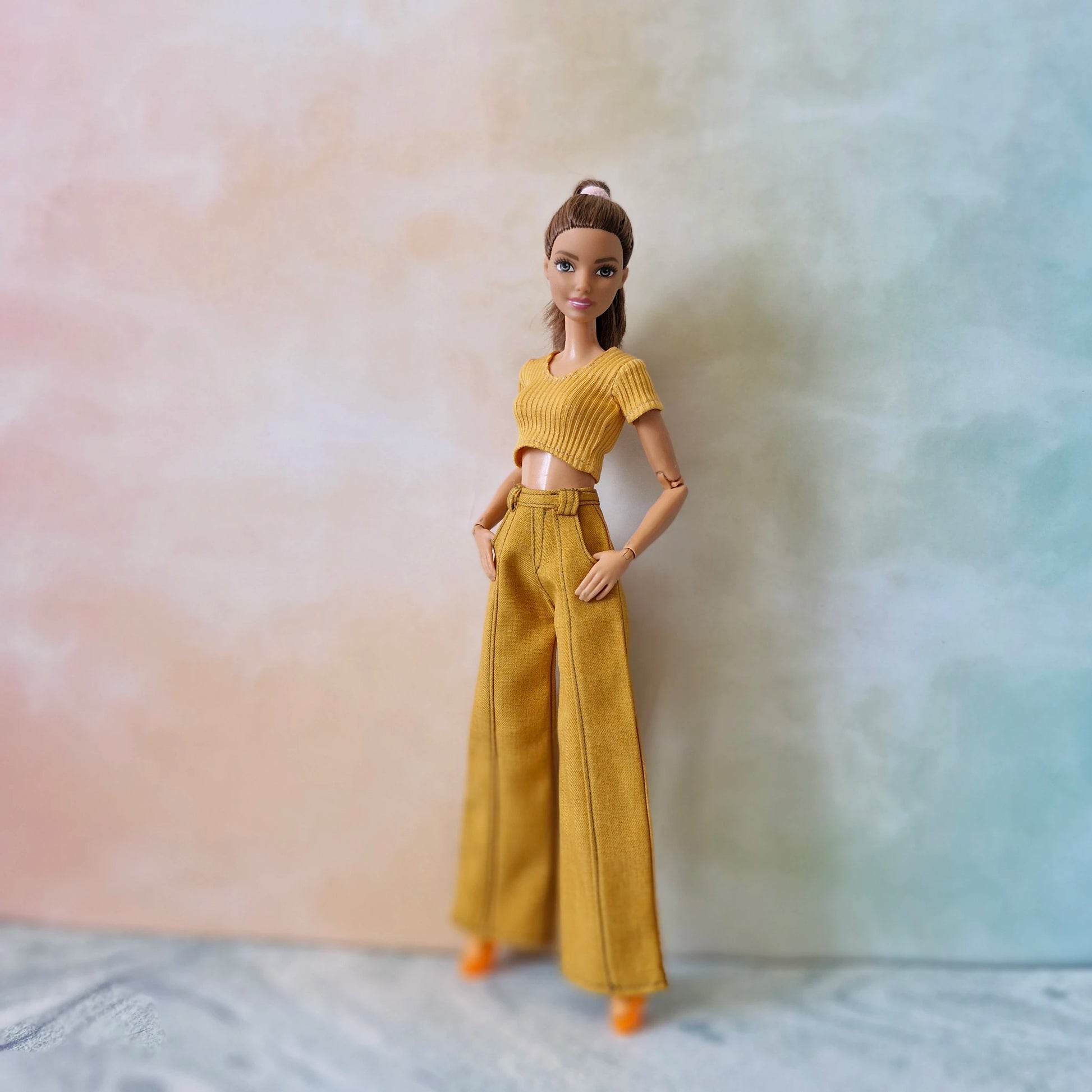 Barbie doll wearing a yellow outfit against a gradient background