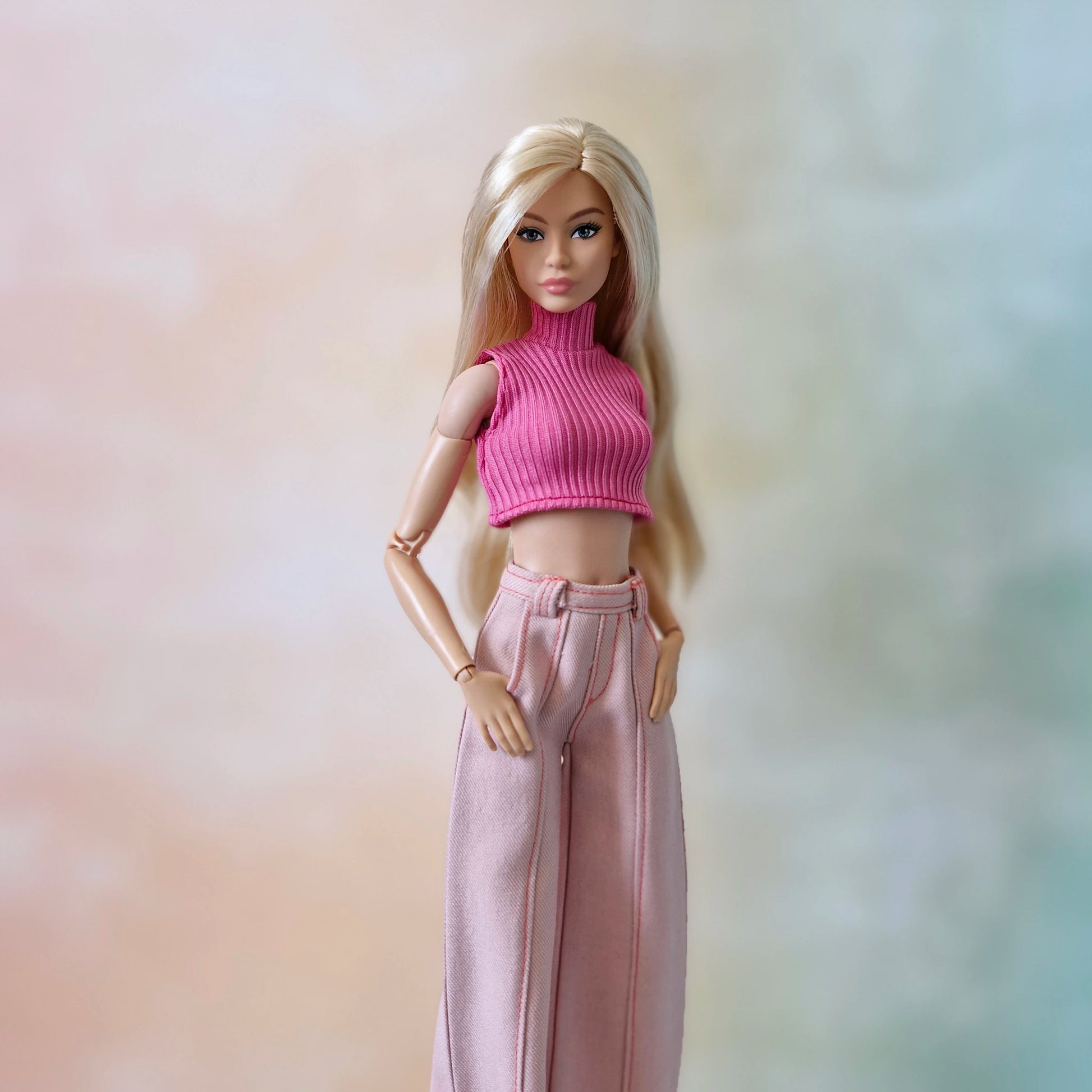Blonde Barbie doll in a pink ribbed sleeveless crop top and light pink wide-leg pants