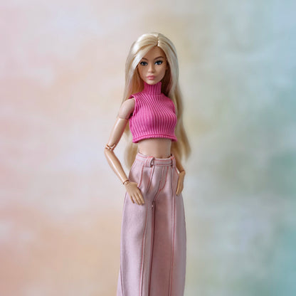 Blonde Barbie doll in a pink ribbed sleeveless crop top and light pink wide-leg pants