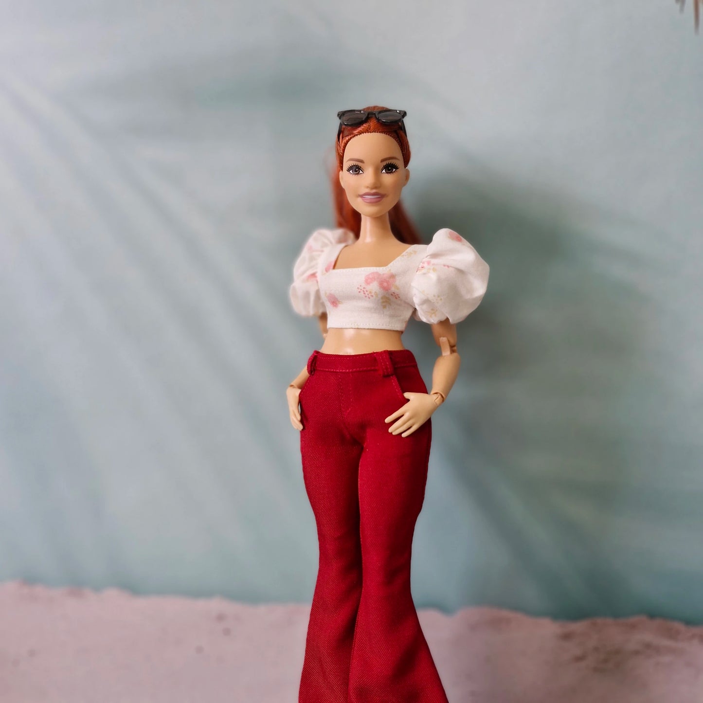 Curvy Barbie doll wearing red bell bottom pants and pink floral puff sleeve top