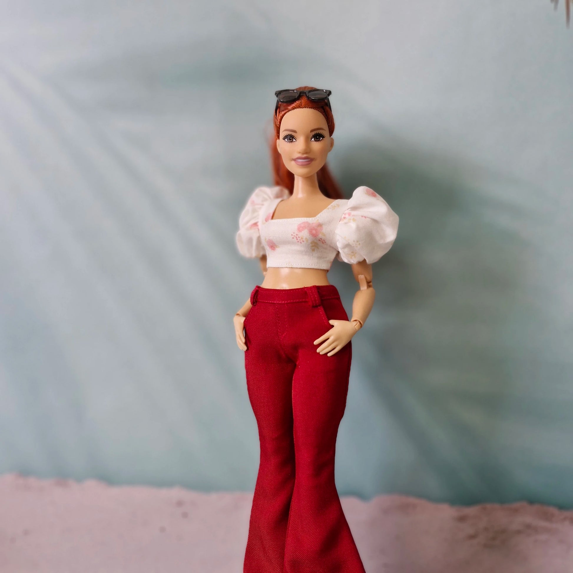 Curvy Barbie doll wearing red bell bottom pants and pink floral puff sleeve top
