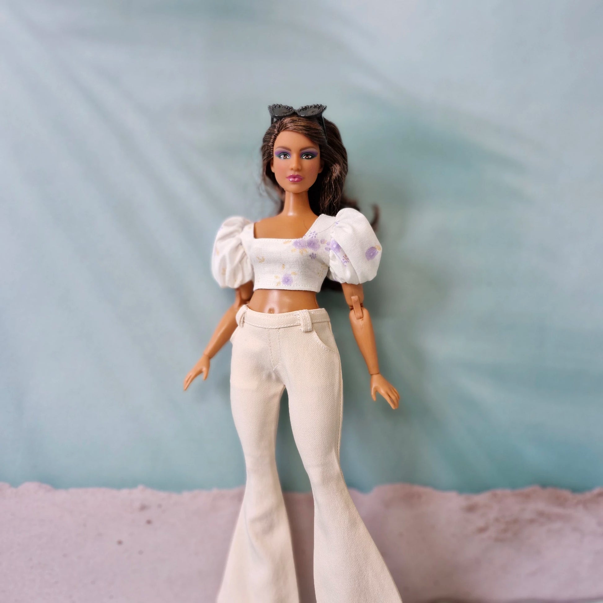 Close up Curvy Barbie outfit with white flared pants and floral crop top