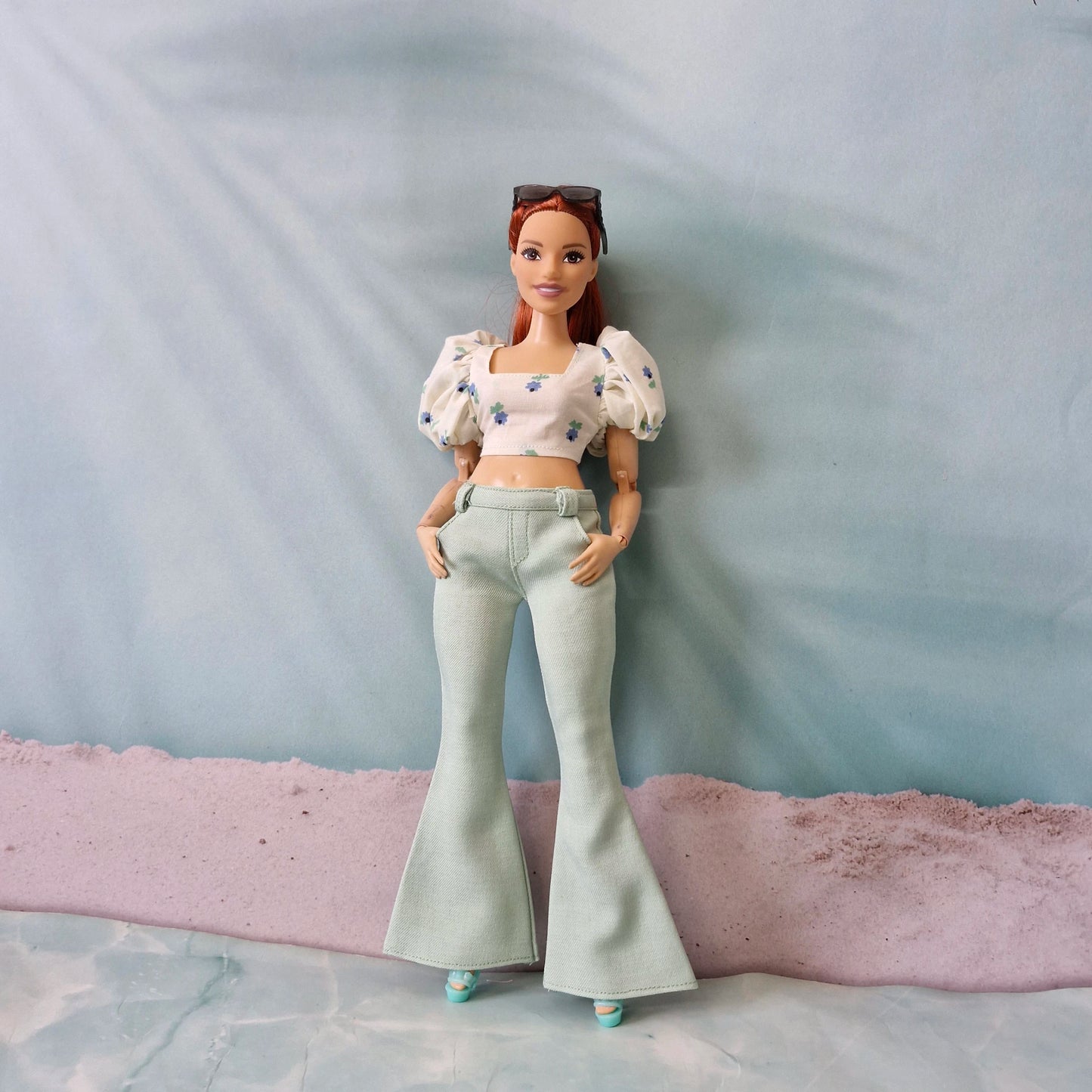 Curvy Barbie doll wearing mint green bell bottom pants and blue floral puff sleeve top