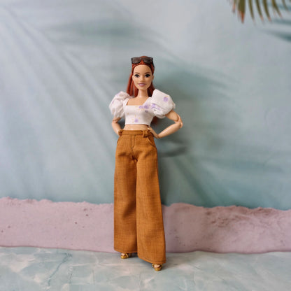 Stylish doll clothes for Curvy Barbie featuring a puff sleeve top and high-waisted brown pants, hands on hips pose.